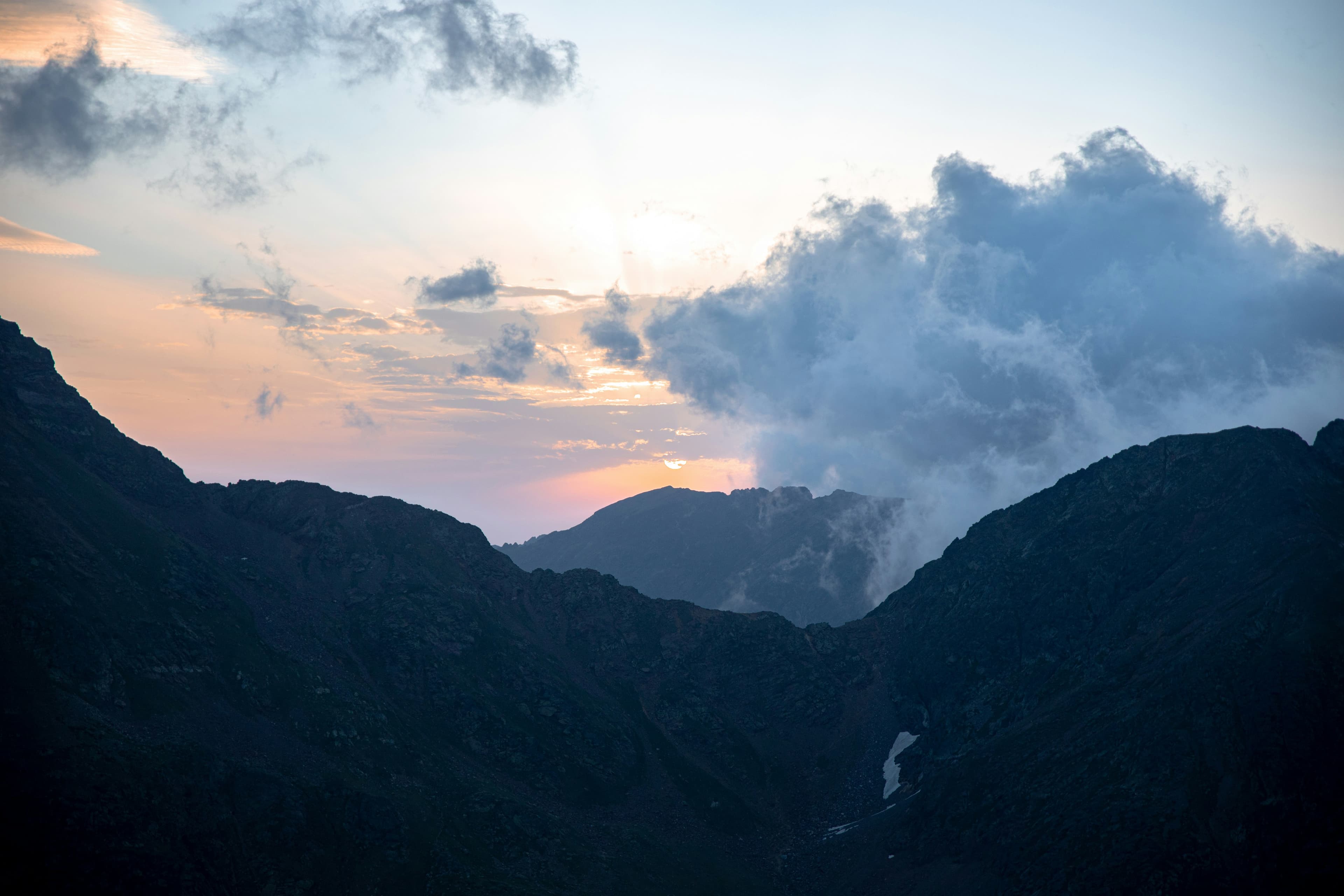 Mountain peaks at sunset with clouds